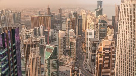 Foto de Vista panorámica del horizonte del puerto deportivo de Dubái que muestra un canal artificial rodeado de rascacielos a lo largo del timelapse aéreo de la costa por la mañana durante el amanecer. Yates y barcos flotantes. DUBAI, Emiratos Árabes Unidos - Imagen libre de derechos