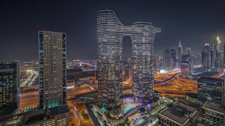 Foto de Panorama mostrando el futurista Dubai Downtown y el horizonte del distrito financiero durante la noche aérea. Muchas torres iluminadas y rascacielos con tráfico en las calles - Imagen libre de derechos