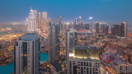 Foto de Marea aérea de una gran ciudad futurista día a noche timelapse transición. Bahía de negocios y distrito centro con muchos rascacielos y casas tradicionales, Dubai, Emiratos Árabes Unidos skyline. - Imagen libre de derechos