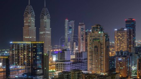 Téléchargez les photos : Des gratte-ciels dans le quartier de Barsha Heights et des tours de ville internet aériennes pendant toute la nuit. Skyline de Dubaï avec lumières éteintes - en image libre de droit
