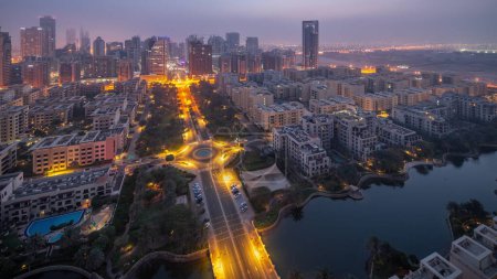 Téléchargez les photos : Des gratte-ciel dans le quartier de Barsha Heights et des immeubles de faible hauteur dans le quartier des Verts se succèdent de nuit au jour. Skyline de Dubaï avec brouillard matinal au lever du soleil - en image libre de droit