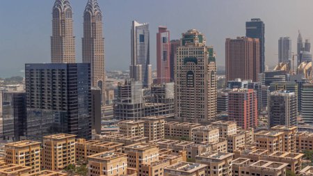 Téléchargez les photos : Des gratte-ciel dans le quartier de Barsha Heights et des immeubles de faible hauteur dans le quartier des Verts toute la journée avec des ombres se déplaçant rapidement dans le temps aérien. Dubai skyline avec internet city - en image libre de droit