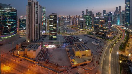 Foto de Business Bay Dubai rascacielos con canal de agua aérea día a noche transición panorámica timelapse. Desarrollo de uso mixto con torres residenciales y de oficinas que comparten la huella por igual - Imagen libre de derechos