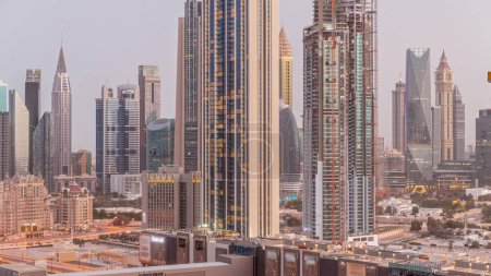 Foto de Panorama of tall buildings around Sheikh Zayed Road and DIFC district aerial night to day transition in Dubai, UAE. International Financial Centre skyscrapers with glass surface before sunrise - Imagen libre de derechos