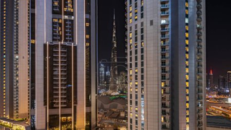 Téléchargez les photos : Panorama montrant les plus hauts gratte-ciel pendant l'heure de la Terre dans le centre-ville de Dubai situé sur la rue bouleward près du centre commercial timelapse nocturne aérienne. Éteindre les lumières pendant une heure - en image libre de droit