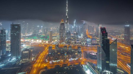 Foto de Vista panorámica aérea de las torres más altas del horizonte y la autopista del centro de Dubái durante toda la noche. Distrito financiero y área de negocios en la ciudad urbana inteligente. Rascacielos y edificios de gran altura - Imagen libre de derechos