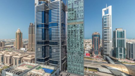 Foto de Panorama que muestra la vista aérea del Distrito Financiero Internacional de Dubai con muchos rascacielos timelapse. Tráfico en la carretera Sheikh Zayed cerca de torres de varios pisos. Dubai, Emiratos Árabes Unidos. - Imagen libre de derechos