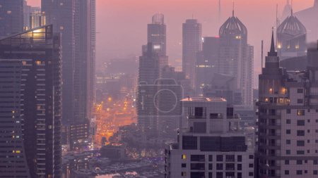 Foto de Dubai Marina y Media City distritos con rascacielos modernos y edificios de oficinas antena noche a día timelapse transición. Tráfico en paso elevado y cruce de carreteras cerca de yates en el puerto - Imagen libre de derechos