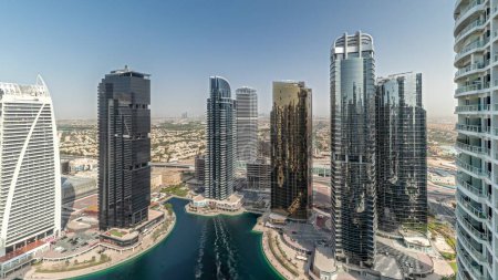 Téléchargez les photos : Panorama montrant de hauts bâtiments résidentiels au JLT district timelapse aérien, qui fait partie du Dubaï multi commodités centre quartier à usage mixte. Villa maisons sur un fond - en image libre de droit