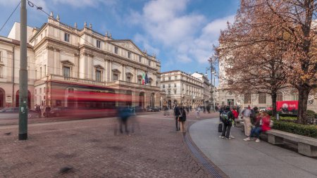 Téléchargez les photos : Panorama montrant le théâtre La Scala timelapse et un petit parc en face du bâtiment historique avec un monument à Léonard de Vinci et ses étudiants. Les gens marchent et s'assoient sur un banc - en image libre de droit