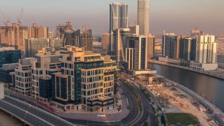 Téléchargez les photos : Quartier de Bay Square au coucher du soleil avec utilisation mixte et immeubles de bureaux complexes de faible hauteur situés à Business Bay à Dubaï. Vue aérienne d'en haut avec la circulation sur la route - en image libre de droit