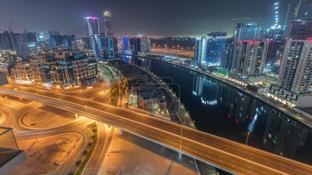 Foto de Rascacielos y torres en Business Bay durante toda la noche en Dubai, Emiratos Árabes Unidos. Vista aérea panorámica desde arriba con canal - Imagen libre de derechos