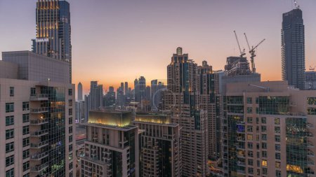 Photo for Dubai skyscrapers with golden sky over business bay district day to night transition . Aerial view from of downtown in United Arab Emirates. - Royalty Free Image