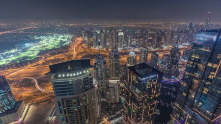 Téléchargez les photos : Panorama of Dubai Marina with JLT skyscrapers and golf course day to night transition , Dubai, United Arab Emirates. Aerial view from above towers after sunset - en image libre de droit