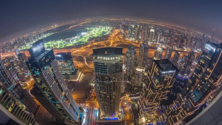 Foto de Panorama of Dubai Marina with JLT skyscrapers and golf course day to night transition , Dubai, United Arab Emirates. Aerial view from above towers after sunset - Imagen libre de derechos