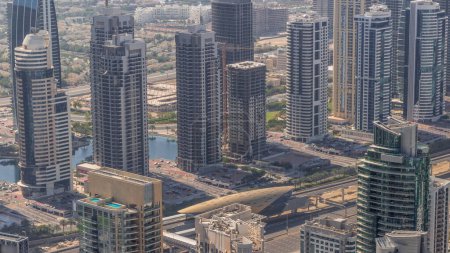 Photo for JLT skyscrapers near Sheikh Zayed Road aerial . Residential buildings and villas with lakes behind. Long shadows moves fast - Royalty Free Image