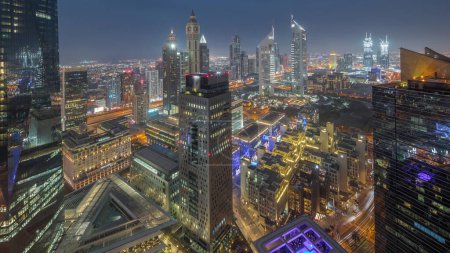 Photo for Panorama of futuristic skyscrapers after sunset in financial district business center in Dubai on Sheikh Zayed road day to night transition . Aerial view from above with museum - Royalty Free Image