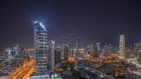 Téléchargez les photos : Panorama showing Dubai's business bay and downtown towers with old town aerial night . Rooftop view of some skyscrapers and new towers under construction - en image libre de droit