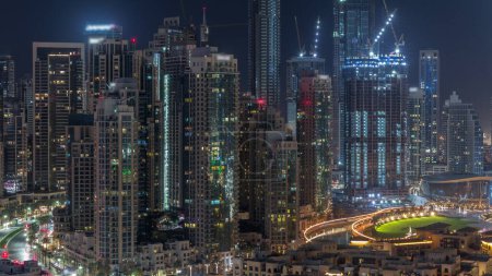 Photo for Futuristic aerial cityscape during all night  with illuminated architecture of Dubai downtown with lights turning off. Many tall skyscrapers and towers. New construction site. United Arab Emirates. - Royalty Free Image