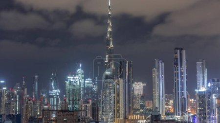 Foto de Skyline panorámico de Dubai con bahía de negocios y el centro de distrito con muchas grúas en el sitio de construcción durante toda la noche. Vista aérea de muchos rascacielos modernos. Emiratos Árabes Unidos. - Imagen libre de derechos