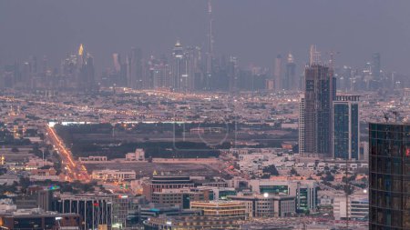 Téléchargez les photos : Dubaï Centre-ville avec quartier financier skyline rangée de gratte-ciel avec tour haut nuit aérienne. Vue d'ensemble loin du toit de la marina de Dubaï. Villa maisons après le coucher du soleil. UAE - en image libre de droit