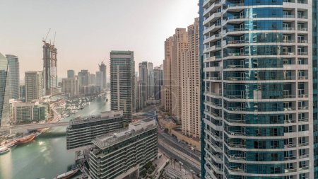 Téléchargez les photos : Panorama showing overview to JBR and Dubai Marina skyline with modern high rise skyscrapers waterfront living apartments aerial . Yachts floating on water of canal. JLT district on a background - en image libre de droit