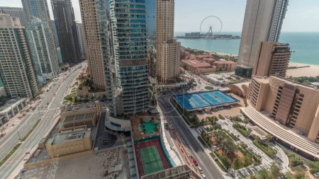 Foto de Vista panorámica de la zona de Dubai Marina y JBR y de la famosa antena de la noria. Playas de arena dorada en el Golfo Pérsico con sombras moviéndose rápido. - Imagen libre de derechos