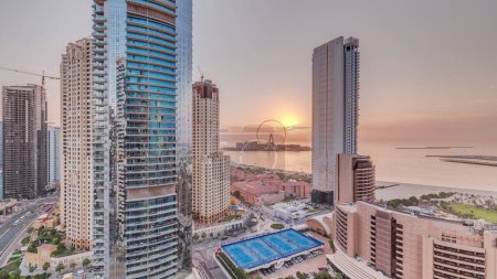 Foto de Panoramic sunset view of the Dubai Marina and JBR area and the famous Ferris Wheel aerial  and golden sand beaches in the Persian Gulf - Imagen libre de derechos