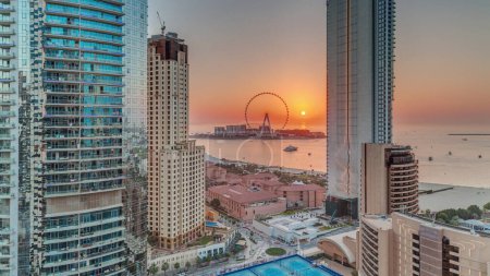Foto de Sunset view of the Dubai Marina and JBR area and the famous Ferris Wheel aerial  and golden sand beaches in the Persian Gulf - Imagen libre de derechos