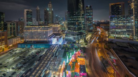 Téléchargez les photos : Panorama showing Dubai International Financial district night . Aerial view of business office towers. Illuminated skyscrapers with hotels and shopping malls near downtown - en image libre de droit