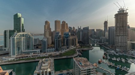 Foto de Panorama showing Dubai Marina with boats and yachts parked in harbor and skyscrapers around canal aerial morning  during sunrise. Towers of JBR district on a background - Imagen libre de derechos