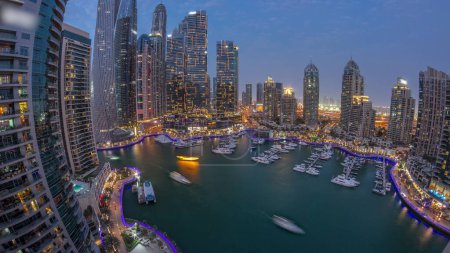Foto de Dubai marina rascacielos más altos panorama y yates en la noche aérea del puerto después de la puesta del sol. Vista en edificios de apartamentos, hoteles y bloques de oficinas, desarrollo residencial moderno de los EAU - Imagen libre de derechos