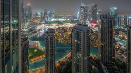 Photo for Dubai downtown with fountains and modern futuristic architecture during all night aerial . Panoramic view to skyscrapers with old town and shopping mall with lights swithcing off - Royalty Free Image