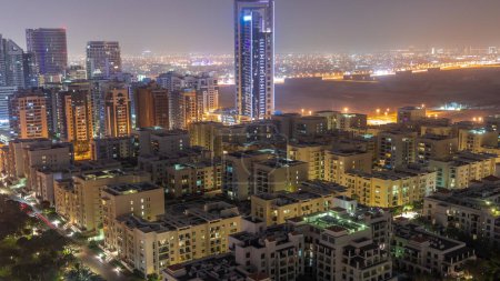 Téléchargez les photos : Des gratte-ciel dans le quartier de Barsha Heights et des immeubles de faible hauteur dans le quartier des Verts pendant toute la nuit. Skyline de Dubaï avec désert sur fond - en image libre de droit