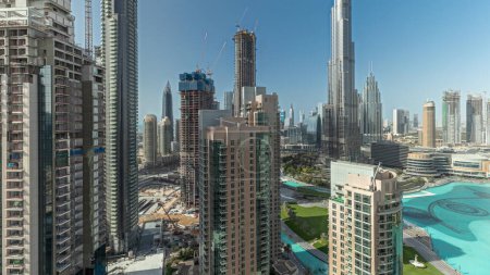 Téléchargez les photos : Panorama showing Dubai Downtown cityscape with tallest skyscrapers around aerial . Construction site of new towers and busy roads with traffic from above - en image libre de droit