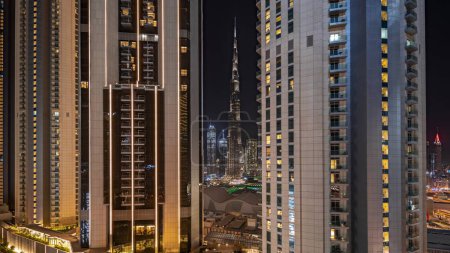 Foto de Panorama showing tallest skyscrapers during Earth hour in downtown dubai located on bouleward street near shopping mall aerial night . Lights turning off for one hour - Imagen libre de derechos