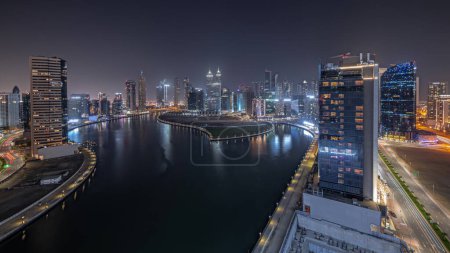 Foto de Panorama que muestra el paisaje urbano de los rascacielos en Dubai Business Bay con noche aérea del canal de agua. skyline moderno con torres iluminadas y paseo marítimo. Un centro de negocios internacionales - Imagen libre de derechos