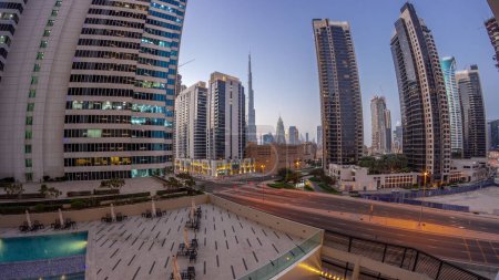 Foto de Panorama aéreo del centro de Dubái y rascacielos difc con tráfico ocupado en la intersección en el distrito de Business Bay transición día a noche . - Imagen libre de derechos