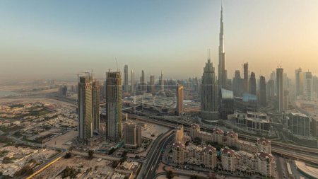 Téléchargez les photos : Panorama showing aerial view of tallest towers in Dubai Downtown skyline and highway  before sunset. Financial district and business area in smart urban city. Skyscraper and high-rise buildings - en image libre de droit