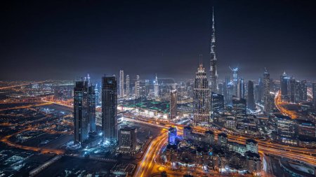 Foto de Panorama showing aerial view of tallest towers in Dubai Downtown skyline and highway night  panorama. Financial district and business area in smart urban city. Skyscraper and high-rise buildings - Imagen libre de derechos