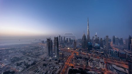 Foto de Aerial panoramic view of tallest towers in Dubai Downtown skyline night to day transition  before sunrise. Financial district and business area in smart urban city. Skyscraper and high-rise buildings - Imagen libre de derechos