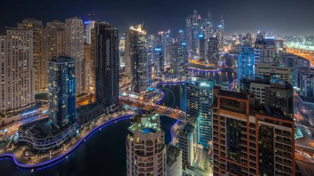 Téléchargez les photos : Panorama showing various skyscrapers in tallest recidential block in Dubai Marina and JDR district aerial night  with artificial canal. Many towers and yachts - en image libre de droit