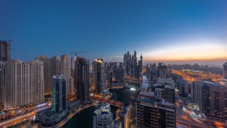 Foto de Panorama of various skyscrapers in tallest recidential block in Dubai Marina aerial night to day transition  with artificial canal. Many towers in JBR district and yachts before sunrise - Imagen libre de derechos