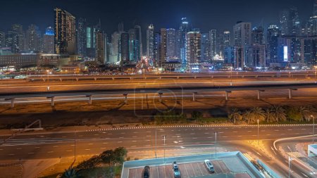 Téléchargez les photos : Panorama showing Dubai marina tallest block of skyscrapers night . Aerial view from JLT district to apartment buildings, hotels and office towers near highway. - en image libre de droit