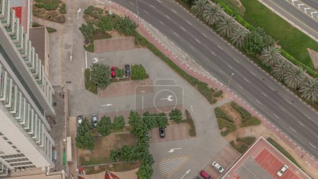 Téléchargez les photos : Parking pour véhicules légers dans le quartier résidentiel de luxe de Dubaï, vue aérienne d'en haut. Gratte-ciel JLT avec de longues ombres se déplaçant rapidement - en image libre de droit
