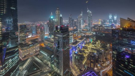 Téléchargez les photos : Panorama of futuristic skyscrapers after sunset in financial district business center in Dubai on Sheikh Zayed road day to night transition . Aerial view from above with museum - en image libre de droit