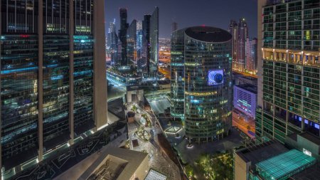 Photo for Dubai international financial center skyscrapers aerial during all night . Illuminated towers and walking area on a gate avenue view from above - Royalty Free Image