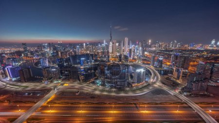 Téléchargez les photos : Panoramic skyline of Dubai with business bay and downtown district day to night . Aerial view of many modern skyscrapers with traffic on al khail road after sunset. United Arab Emirates. - en image libre de droit