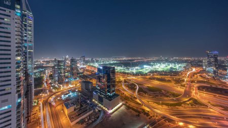 Foto de Aerial panoramic view of media city and al barsha heights district area day to night transition  from Dubai marina. Towers and skyscrapers with traffic on a highway from above - Imagen libre de derechos