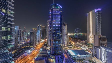 Téléchargez les photos : Vue panoramique sur la Marina de Dubaï et le quartier JBR et sur la célèbre Grande Roue. Aérien pendant toute la nuit et gratte-ciel illuminé avec lumières éteintes - en image libre de droit